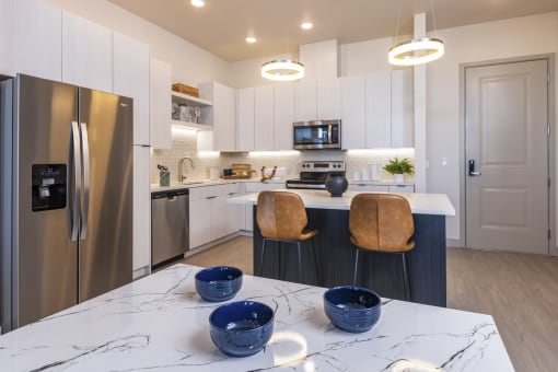 a kitchen with stainless steel appliances and quartz counter tops at Zeta Luxury Apartments in Sacramento, CA
