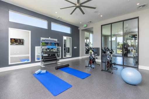 a gym with yoga mats and exercise equipment at the Solasta apartments