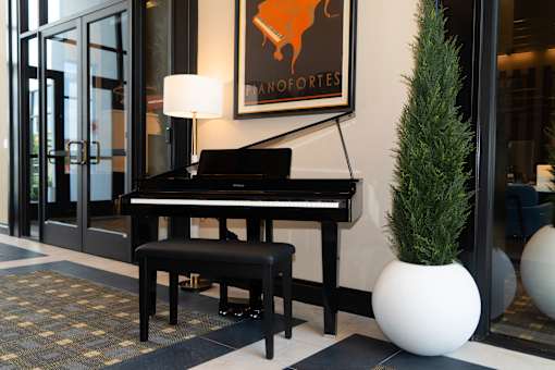 A piano and stool in resident lounge at Amara
