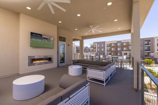 outdoor balcony resident lounge with fireplace and large screen television at Element 12