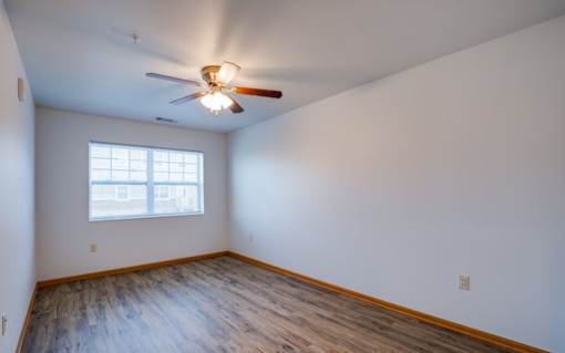 A room with a ceiling fan and a window.