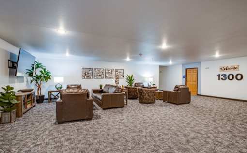 A room with a carpeted floor and a wall with a number 1300 on it.