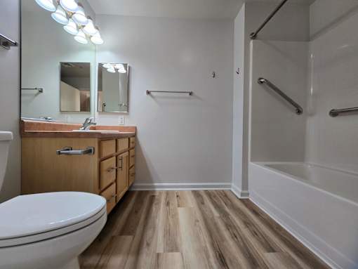 A bathroom with a toilet, sink, and mirror.