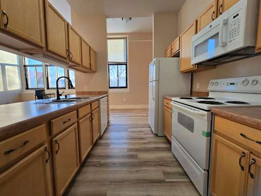 A kitchen with wooden cabinets and white appliances.