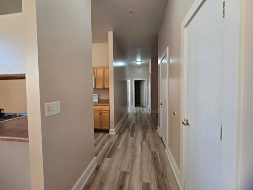 A long hallway with a white door at the end.