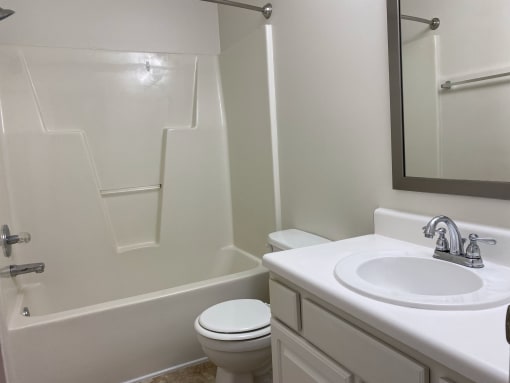 A bathroom with a sink toilet and bathtub.