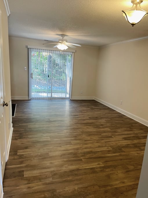 An unfurnished living room with a sliding glass door.