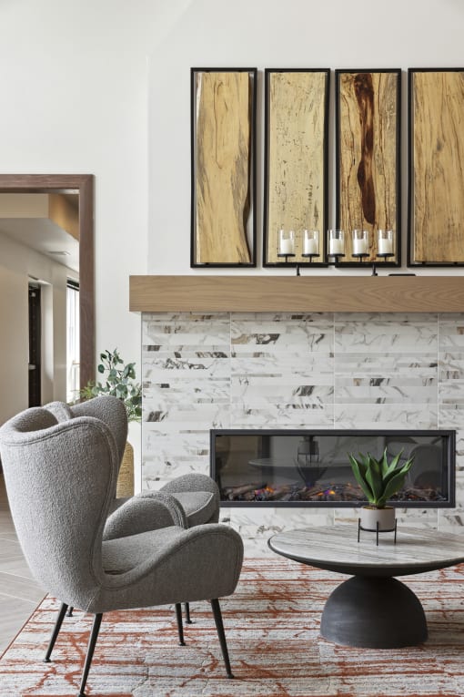 a living room with a fireplace and two chairs