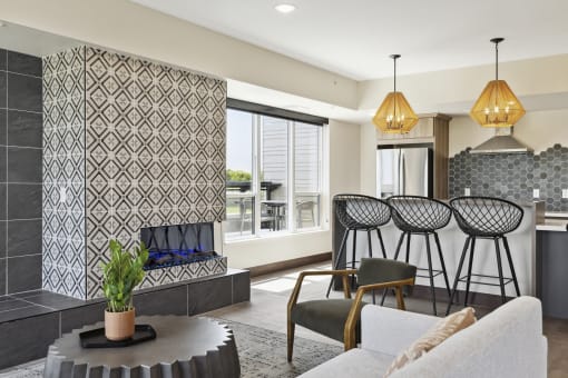 a living room with a fireplace and a kitchen in the background