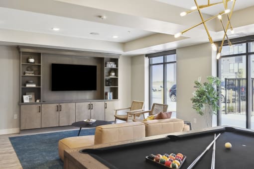 a living room with a pool table and a tv