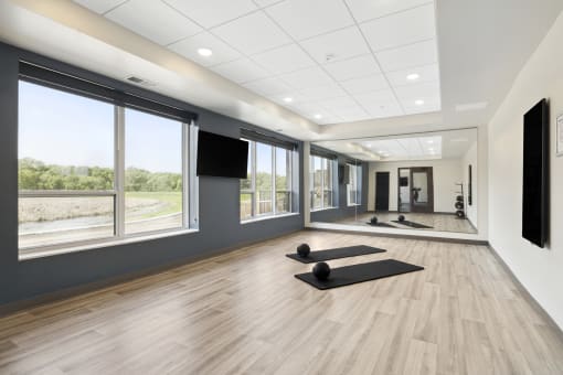 a spacious yoga studio with large windows and a large screen tv
