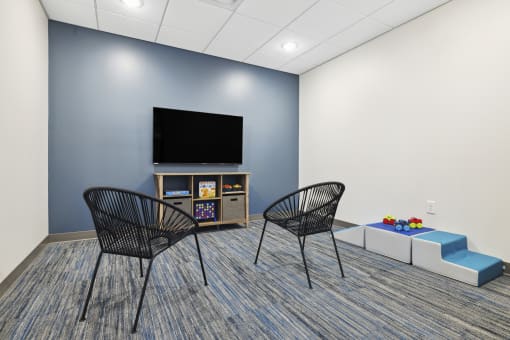 a room with two chairs and a table with a television on top of it