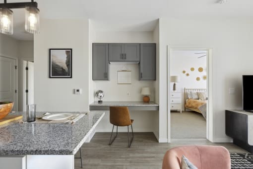 a kitchen with a breakfast bar and a bedroom in the background