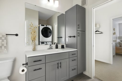 a bathroom with gray cabinets and a white countertop