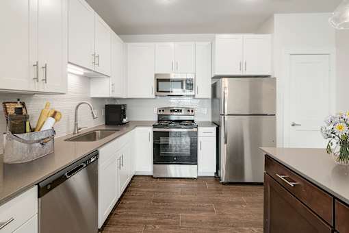 A kitchen with white cabinets and stainless steel appliances.