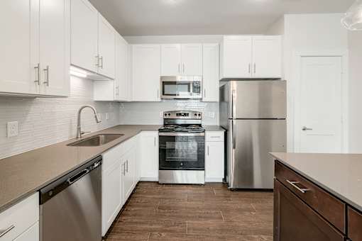 A modern kitchen with stainless steel appliances and white cabinets.