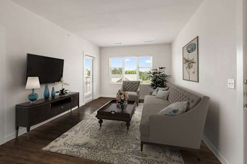 A living room with a grey couch, a coffee table, and a television.