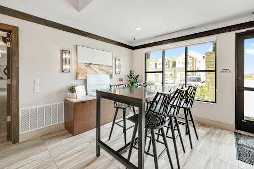 A dining room with a table and chairs.