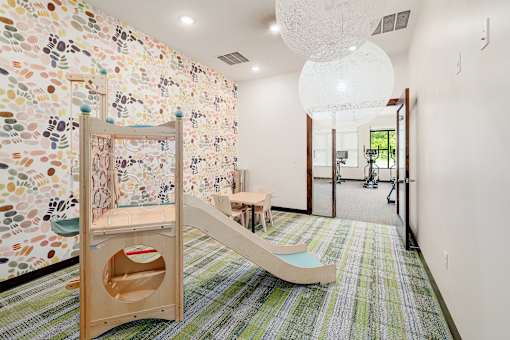 A room with a colorful wallpaper and a wooden play structure.