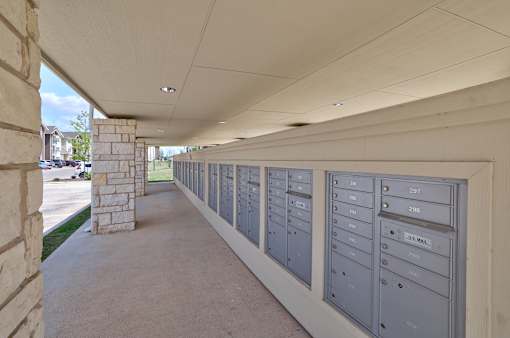 A long row of mailboxes are lined up on the side of a building.