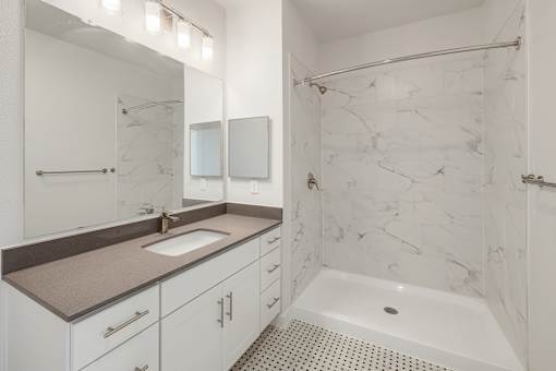 A white bathroom with a marble shower.