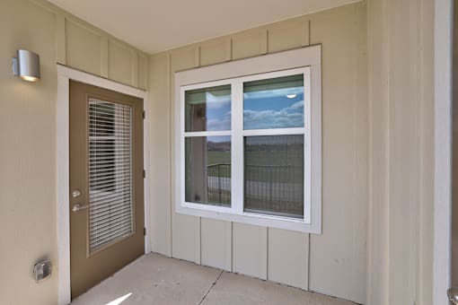 A white window with a view of the sky and a fence outside.