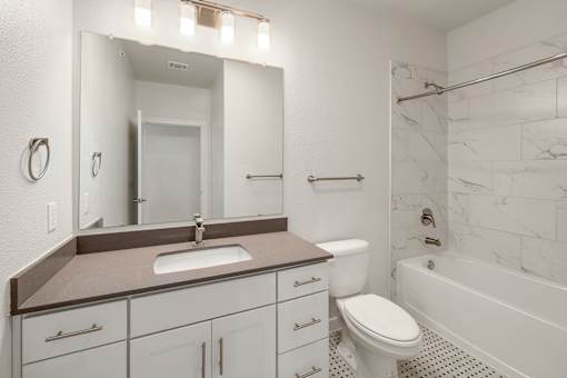 A bathroom with a sink, toilet, and bathtub.