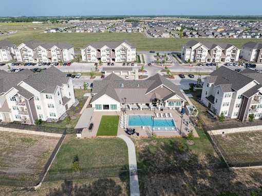 A bird's eye view of a residential area with houses and a swimming pool.