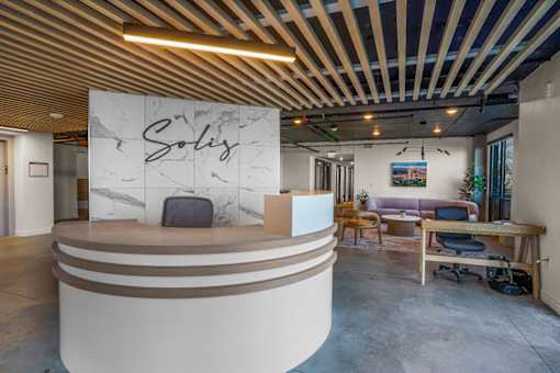 A reception area with a white reception desk and a sign that says "Sales".