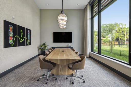 a conference room with a table and chairs and a large window