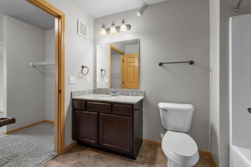 the ensuite bathroom with a shower and tub at the enclave at woodbridge apartments in sugar