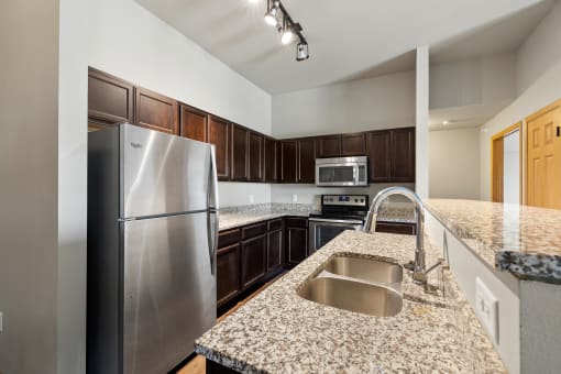 a kitchen with granite countertops and stainless steel appliances