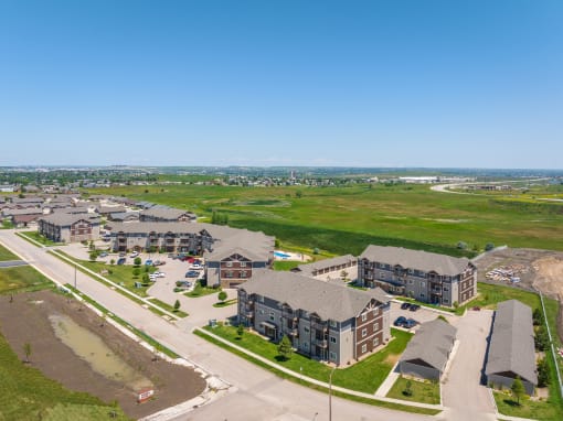 an aerial view of a large housing complex with a green field in the background