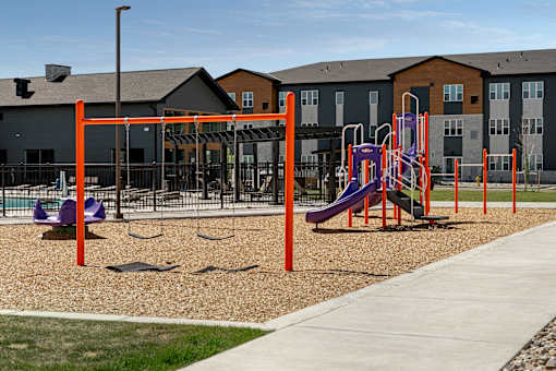 A playground with a purple slide and orange poles.