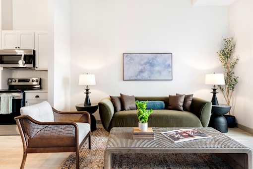 A living room with a brown chair, a green couch, and a grey coffee table.