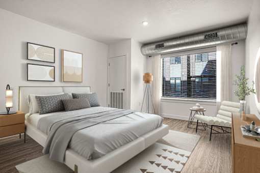 A bedroom with a large bed, a chair, and a nightstand with a lamp.
