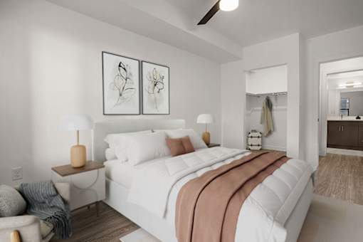 A bedroom with a large bed and two lamps.