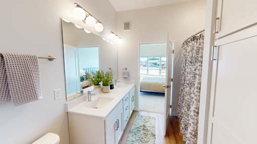 A bathroom with a white sink and a mirror.