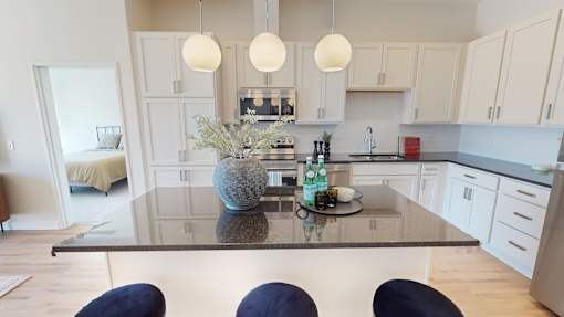 A modern kitchen with a glass table and blue chairs.