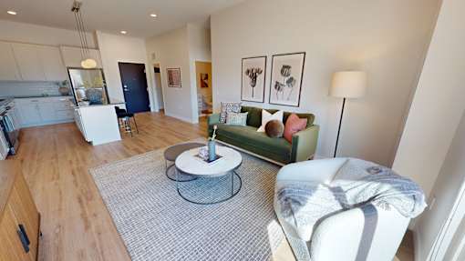 A living room with a grey rug and a white chair.