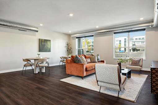 A living room with a brown couch and a white chair.