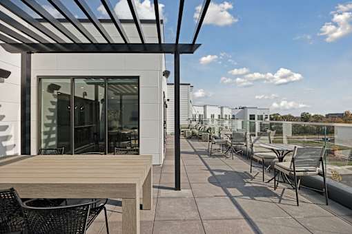 A patio with a table and chairs is covered by a roof.