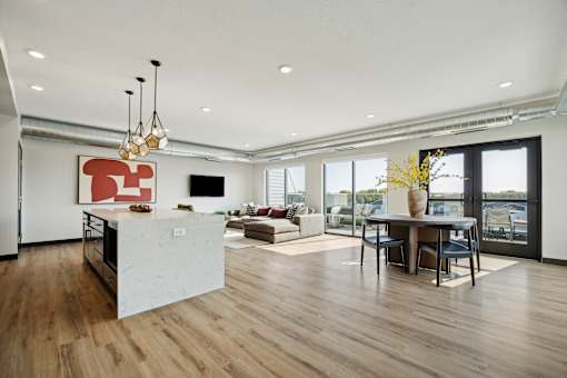 A modern kitchen with a white island and wooden floors.
