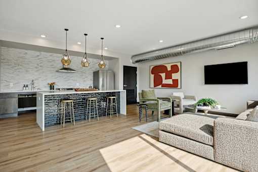 A modern living room with a kitchen area in the background.