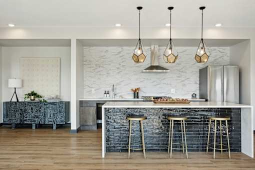 A kitchen with a white counter top and a black refrigerator.