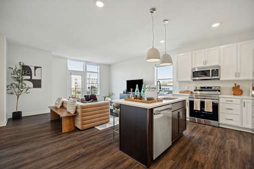 A modern kitchen with a wooden floor and white walls.