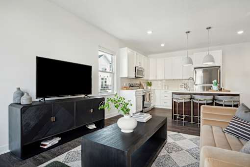 A black TV sits on a black cabinet in a modern living room.