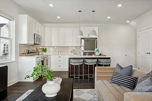 A modern kitchen with white cabinets and a wooden floor.