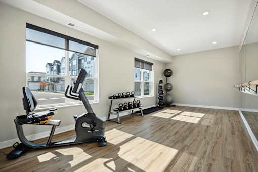 A home gym with a treadmill, weights, and exercise equipment.
