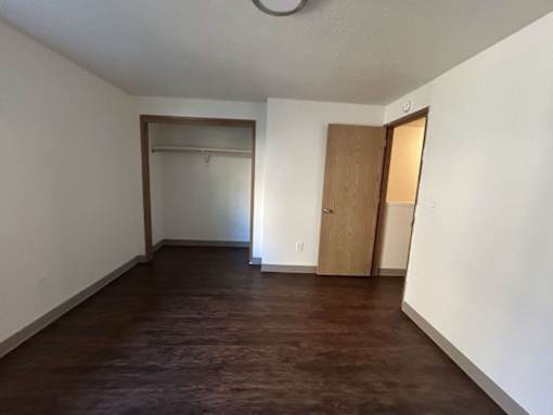 A room with a brown floor and white walls.